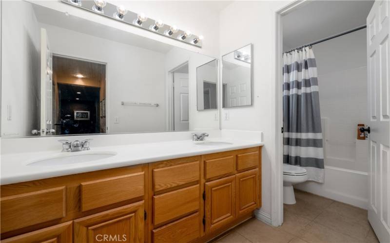 Secondary bathroom with double sink vanity.