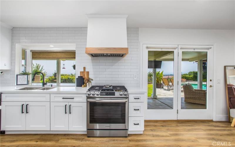 QUALITY CUSTOM CABINETRY WITH MODERN TILE BACKSPLASH THAT GOES ALL THE WAY TO THE CEILING.