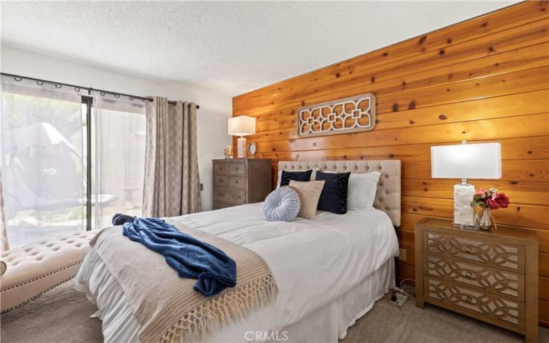 Primary bedroom with STUNNING wood wall.