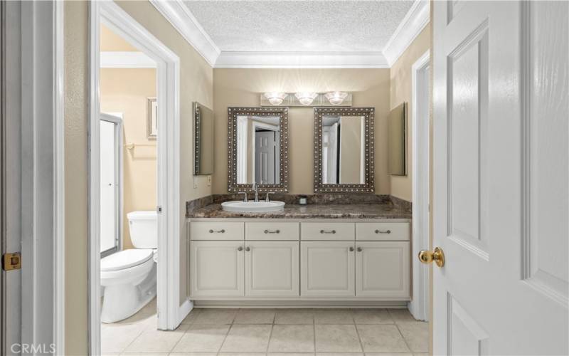 En suite primary bathroom with updated vanity.