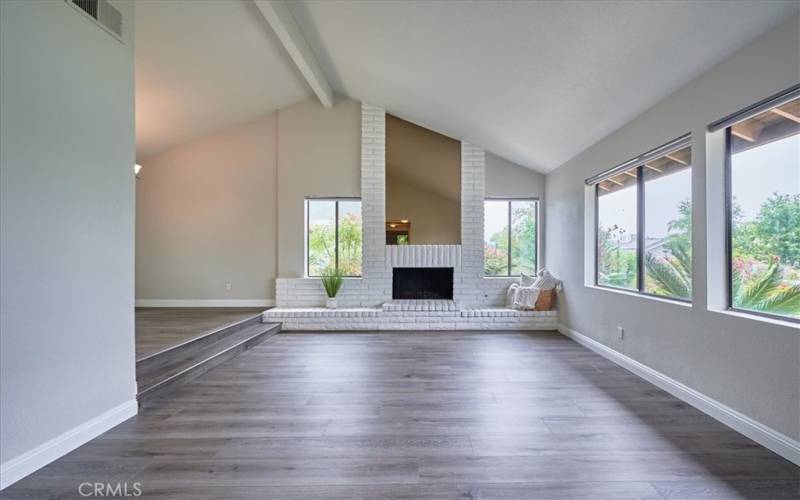 Expansive living room with floor to ceiling fireplace, oversized hearth and windows galore!