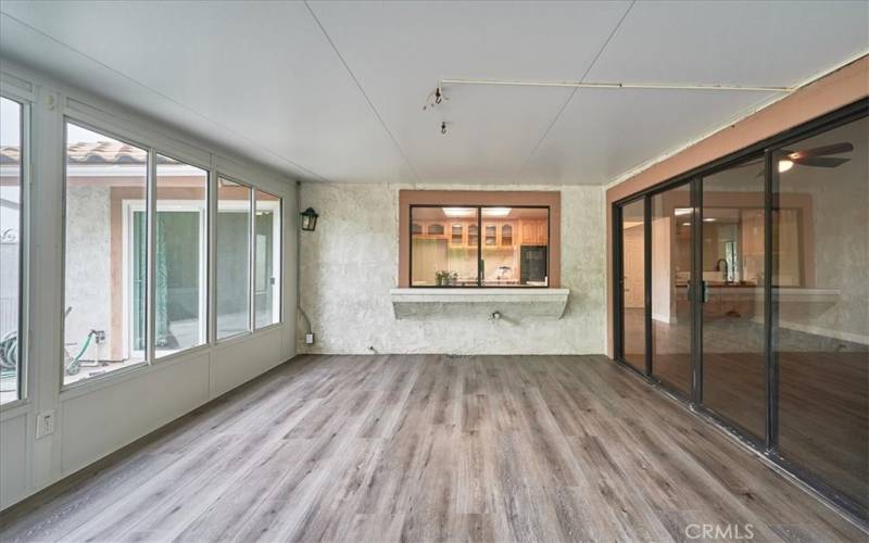 Sunroom with window to open to the kitchen and sliding door that opens to the gathering room