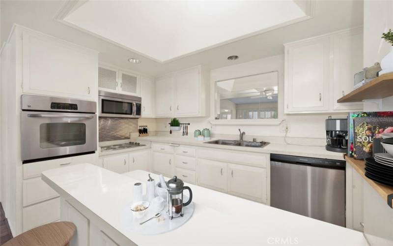 Stainless steel appliances, over, microwave, dishwasher, 4 burner stovetop with stainless back splash  large kitchen sink. Virtual staging