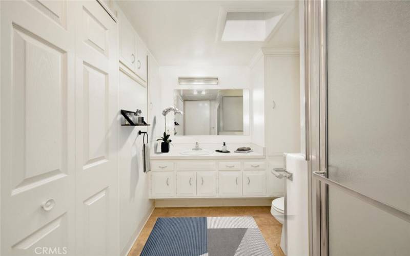 Three quarter bath with grab bars. Plenty of storage in this skylit bathroom.  Virtual staging.