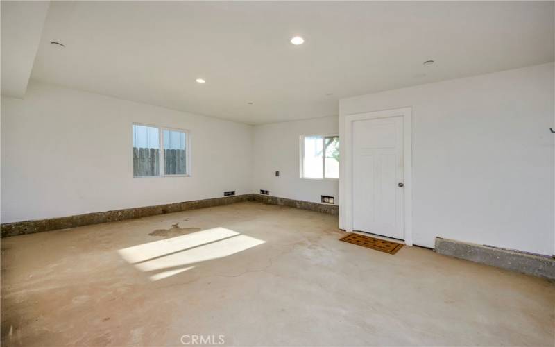 Room between house entrance and drive in garage with lots of light and space.