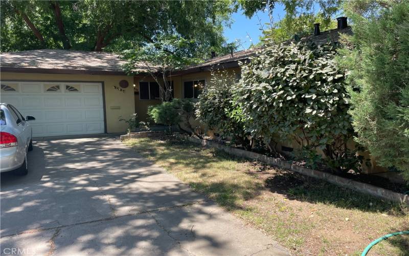 Front view, drive way and view of garage door, enty door to the right