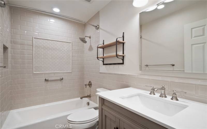 The completely upgraded main full bath has new modern cabinetry and a custom finished shower.