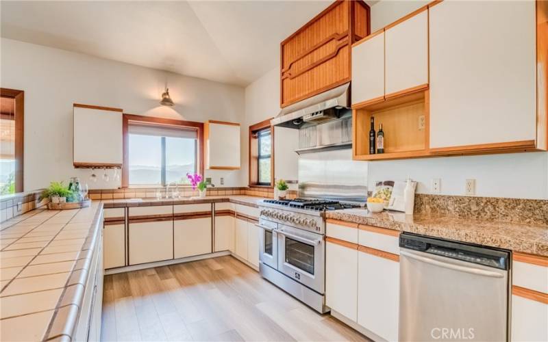 Amazing kitchen features professional style six burner stove with double oven, lots of counter space and storage...
