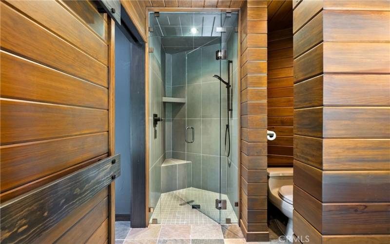Walk in shower and wood wrapped walls add to the elevated feel.