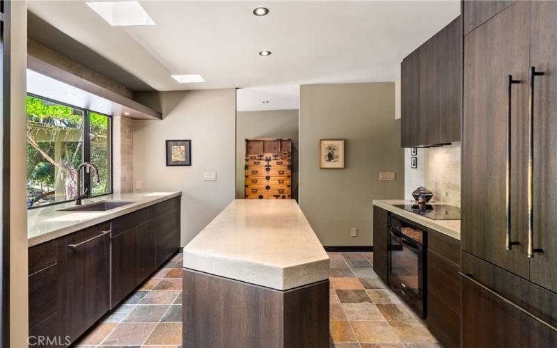 Elevated kitchen offers concrete countertops and panel front appliances to blend in seamlessly.