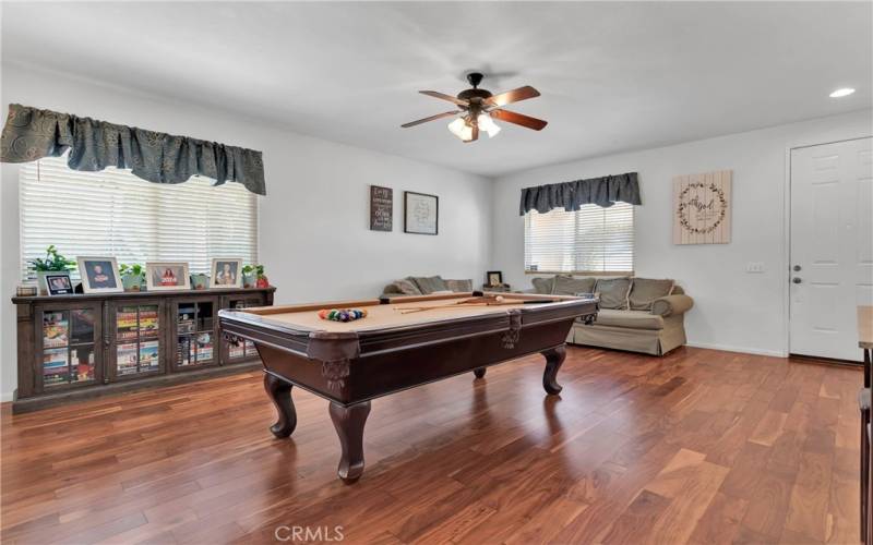 Wood flooring in this oversized game room. This space could be set up as a formal dining room.