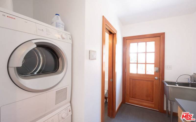 Laundry Room with stacked washer & dryer and a laundry tub