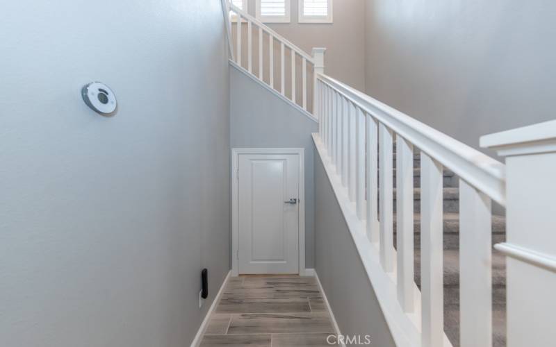 smart thermostat; small door leads to spacious storage area under staircase