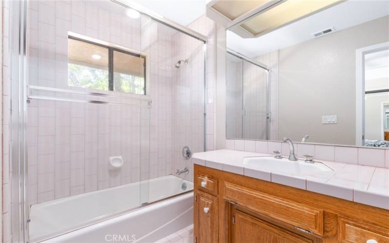 The ensuite bathroom has a tiled tub/shower combination and plenty of storage.