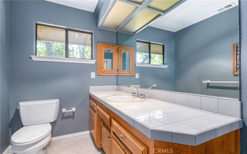 The main bathroom offers a sizeable vanity and tile floors.
