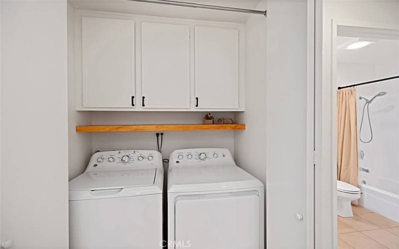 Down the hall, discover the washer and dryer area, complete with additional storage cabinets for your convenience. Keep everything tidy and organized while taking care of laundry tasks effortlessly.
