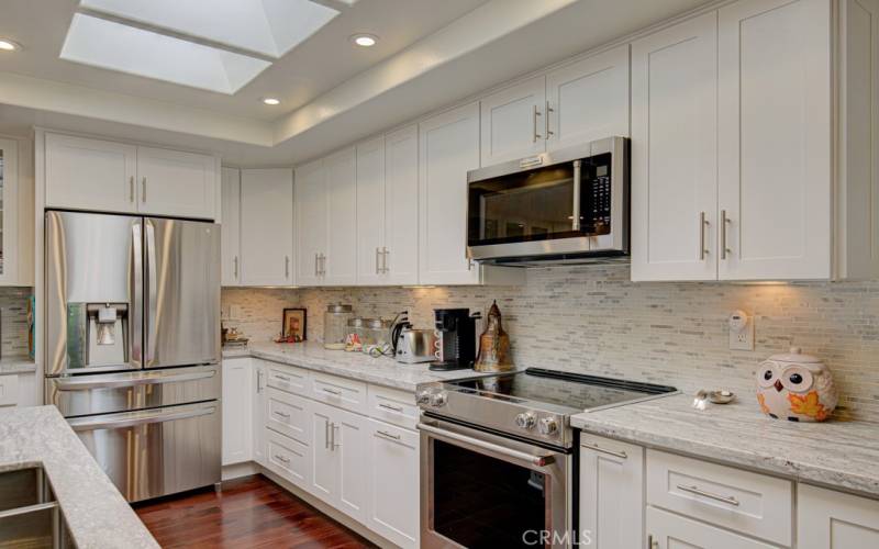 Expanded gourmet kitchen features many cabinets and ample countertop space. Additional upgrades include a tasteful tile backsplash, high-end appliances (including an LG fridge and two-drawer Fisher & Paykel dishwasher), cabinet underlighting, spice drawer, lazy susan and large skylight.