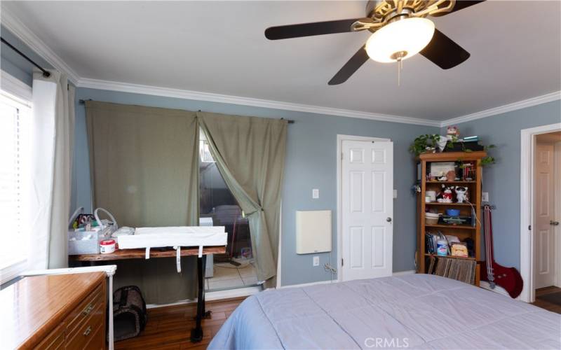 bedroom has large walk in closet (white door) and balcony behind curtain