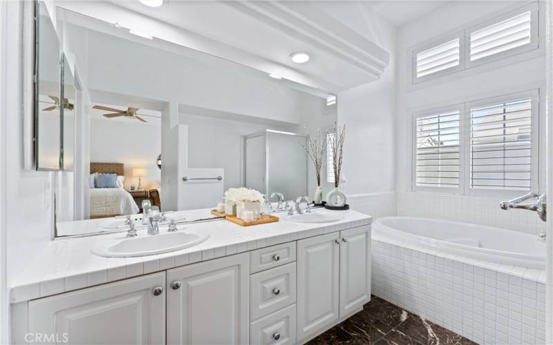 Ensuite bathroom with dual vanity sink, separate tub and shower.