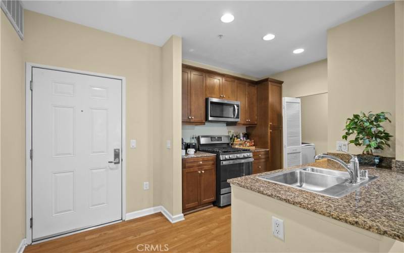 Entrance and kitchen with granite and stainless steel appliances