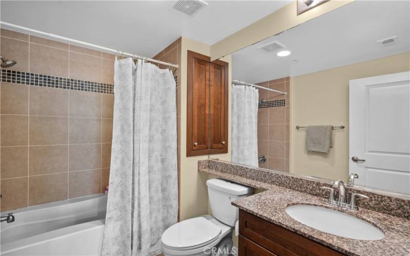 Primary bathroom with granite and shower in tub