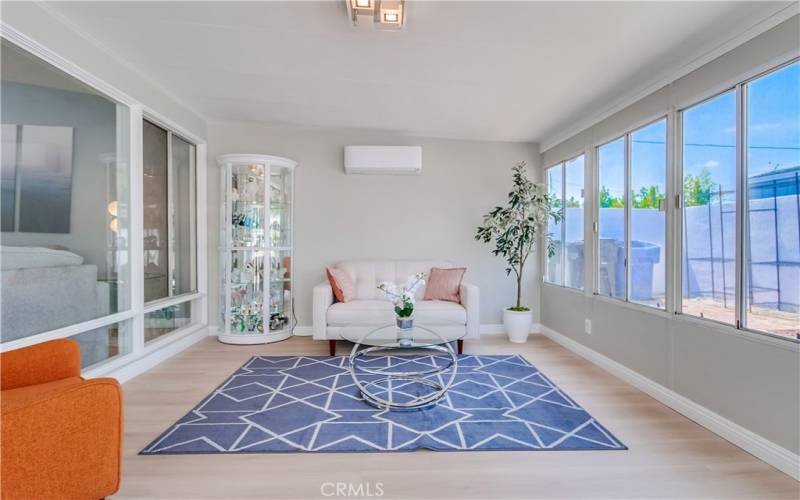 You're sure to love this permitted enclosed patio room that has been made even better with a new mini-split AC, gorgeous flooring, and modern lighting.