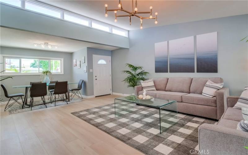 Warm, inviting, and modern living room at the entry boasts waterproof vinyl flooring, so is perfect for entertaining in style