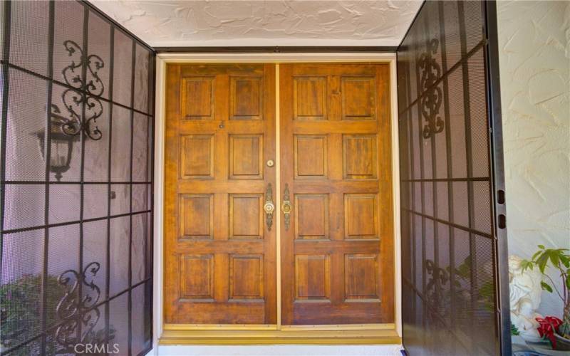 Double iron and wood doors at front entry.