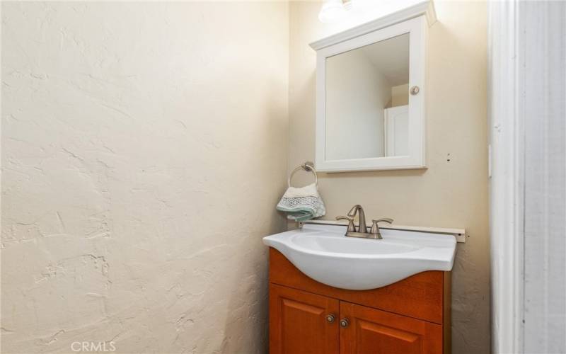 The half bathroom off the laundry features a newer vanity and medicine cabinet above the sink.