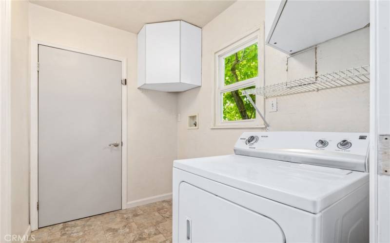 The interior laundry room offers cabinets for more storage. Door leads out to the attached carport.