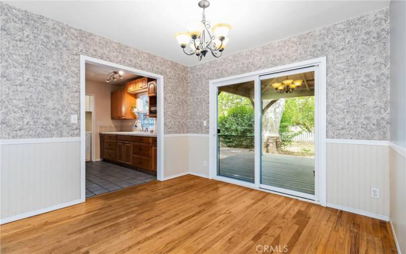 The dining area is adorned with wainscotting and a brilliant sliding glass door that accesses the backyard.