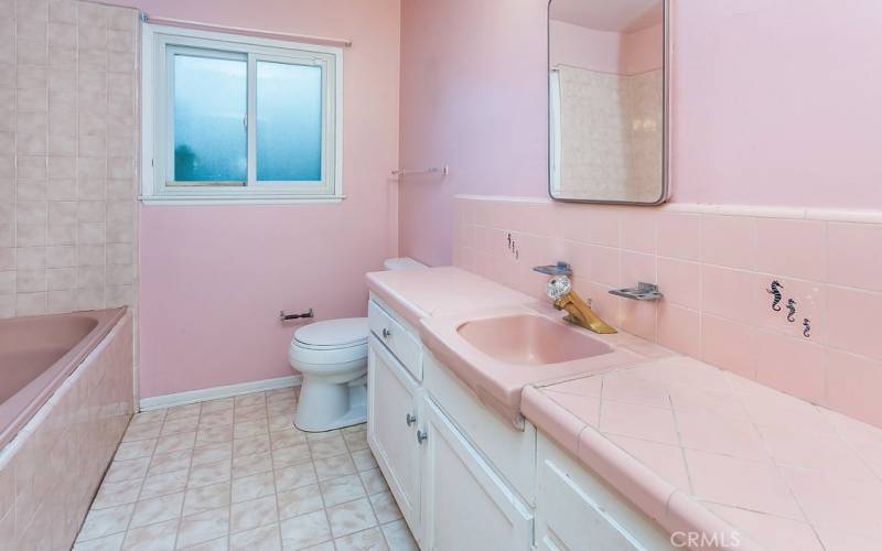 Full guest bathroom with vanity, tiled counter tops, dressing mirror with medicine storage, tiled jetted tub/shower, privacy window and easy-care floors.