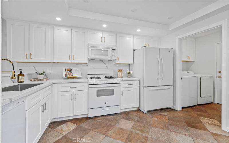 Fully remoddeled Kitchen with White shakers cabinets and qourtz counters and back splash with utility SS sink and Golf faucets.