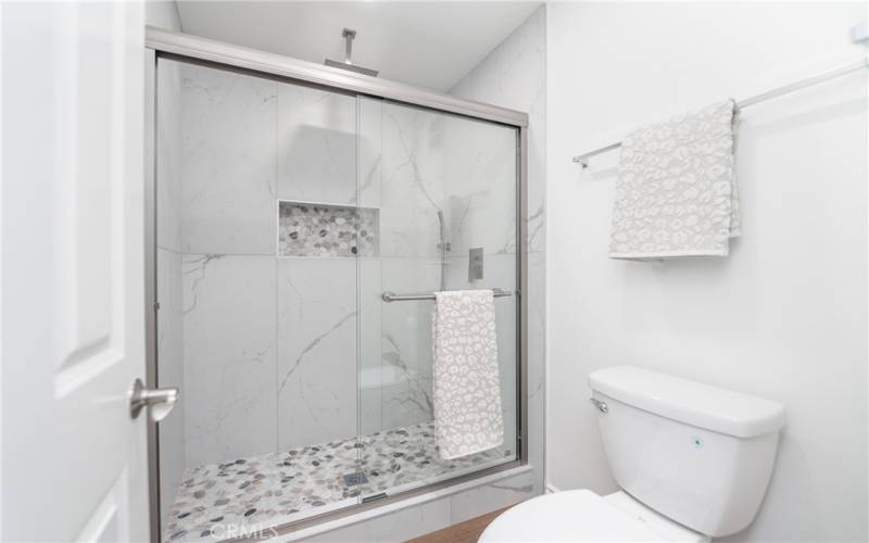 Gorgeous remodeled Shower with new recessed lights and new toilet and brand new shower and faucet fixtures and SS Glass door area and special design Quartz and base tiles.