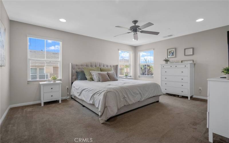 Huge primary bedroom with ceiling fan.