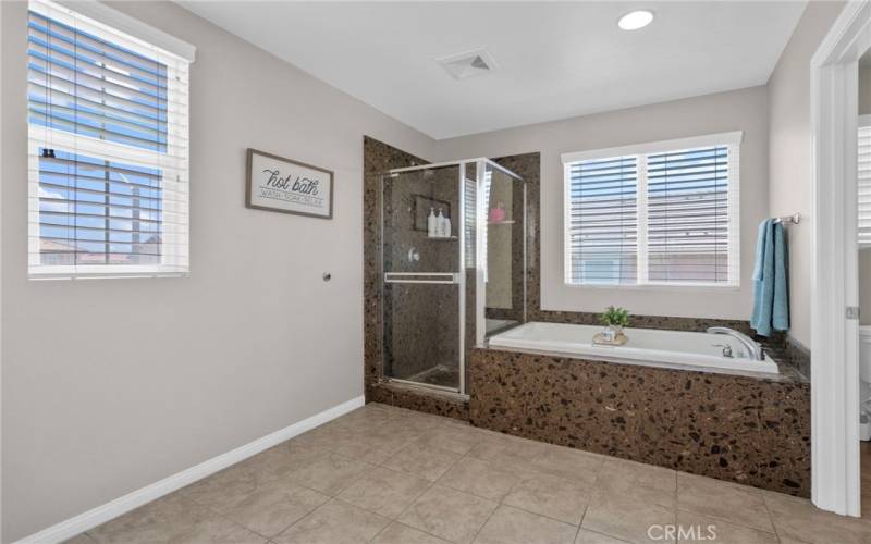 Beautiful marble surrounds the shower & separate large soaking tub in primary bathroom