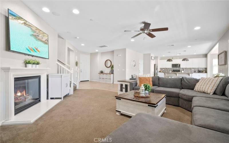 Family room with ceiling fan & fireplace.  Outlet for the TV installed in the wall behind the TV.