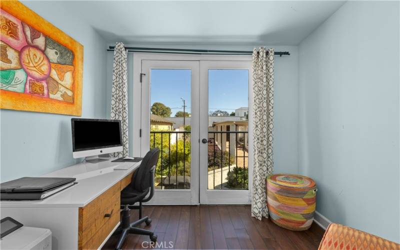 The “Juliet balcony” is located in the primary bedroom and overlooks the garden and pool.