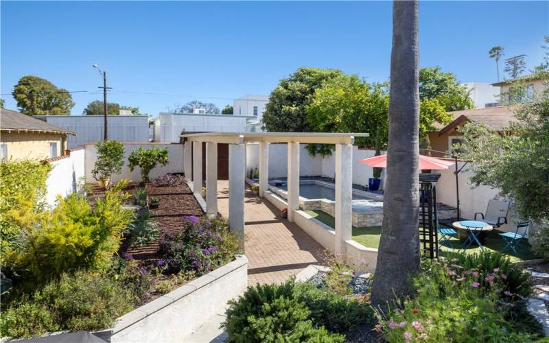 The center allee leads to the fully enclosed, splendid front yard with gorgeous pool and spa, fruit trees, vegetable garden and lounging areas.