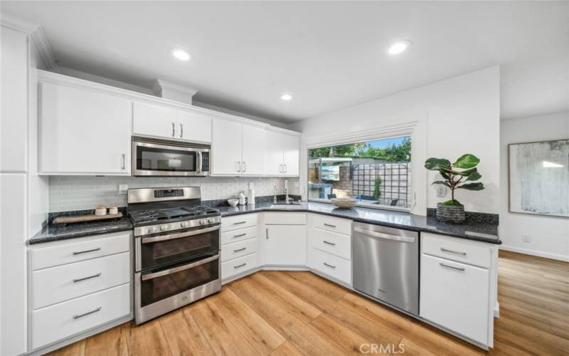 Stainless-steel appliances & a large window for peaceful, backyard views