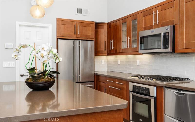 Kitchen features new backsplash and stainless steel appliances