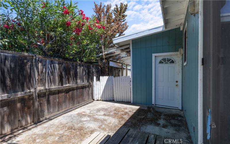 Side yard, with a door to the garage and a gate to the front of the home.