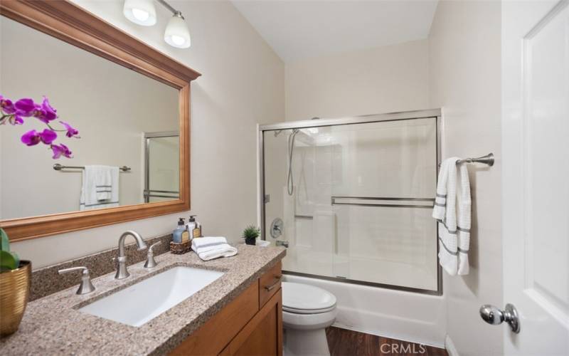 Hallway bath with granite countertops & glass shower enclosure