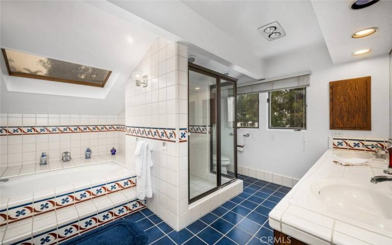 Primary ensuite bathroom with large bathtub, walk in shower and walk in closet attached