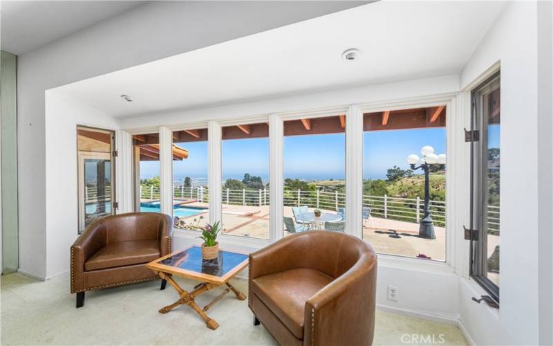 Formal LR seating area with pool & view in background