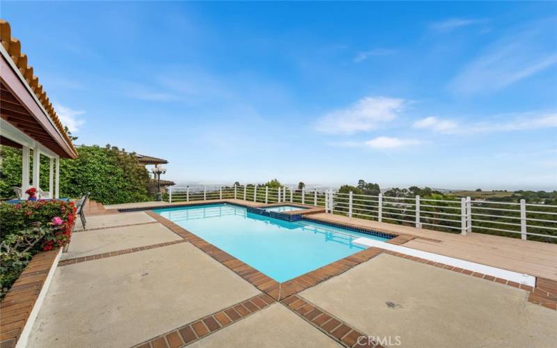 View of pool, jacuzzi, deck and view