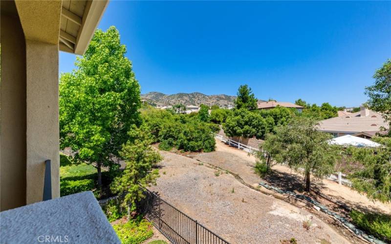 Westerly view from covered rear-patio deck toward backyard avocado groves and Trilogy community walking path,