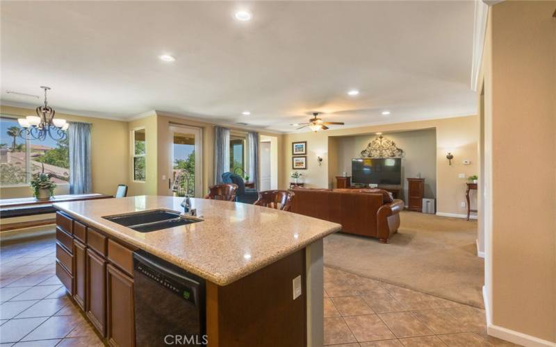 Black appliances and sink blend nicely with the huge Quartz Center Island.