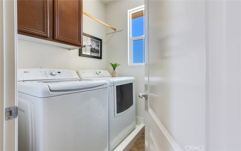 This separate inside Laundry Room in the Hallway, comes with appliances. Note the handy storage cabinets and clothes pole.