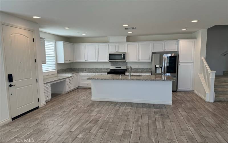 Spacious kitchen with a granite countertop island that comfortably seats three for dinner.
